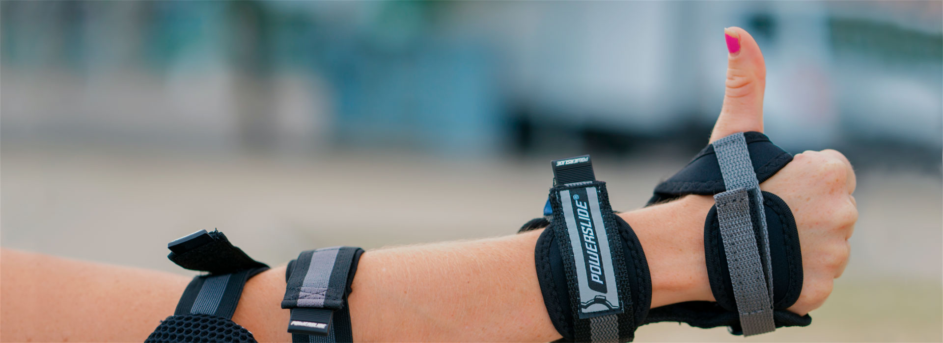 A close-up image of a person wearing a Powerslide wristguard and giving a thumbs up